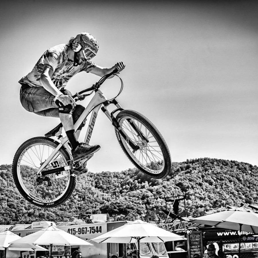 Black and white action photograph of a cyclist midair
